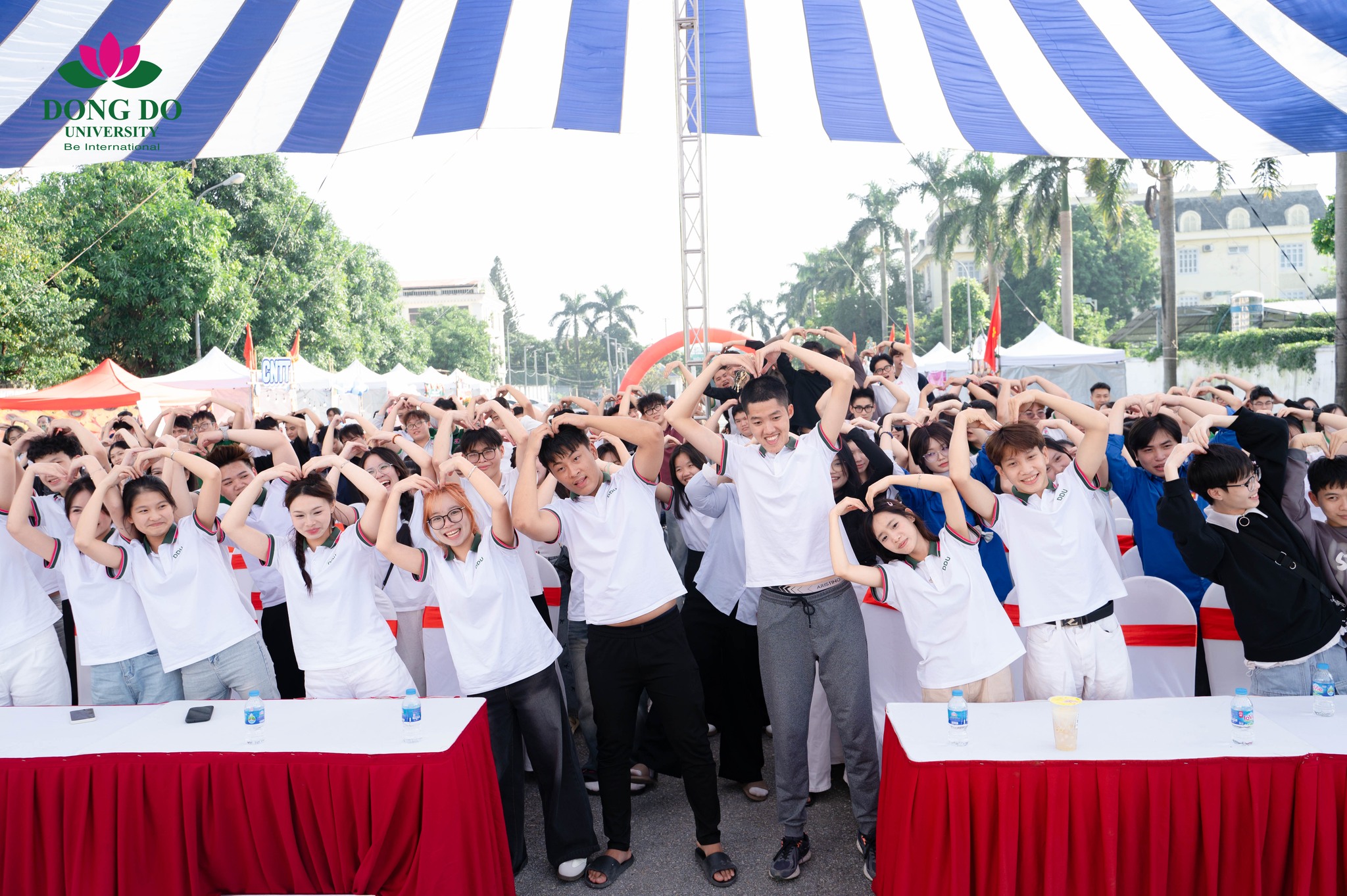 Sân trường nhộn nhịp với âm nhạc, tiếng reo hò cổ vũ và sắc màu từ những đội tham gia teambuilding